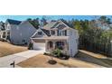 Two-story house with gray siding, brick accents, and a three-car garage at 505 Blue Mountain Rise, Canton, GA 30114