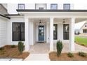 Covered front porch with brick flooring, white columns, and a blue door at 488 Broom Dr, Cumming, GA 30040