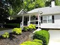 Inviting home exterior boasts lush landscaping, a covered front porch, and an attached garage at 213 Moore Valley Way, Canton, GA 30115