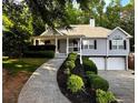 Beautiful home with meticulously landscaped front yard, covered porch, and attached two-car garage at 213 Moore Valley Way, Canton, GA 30115