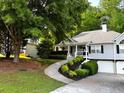 Well-maintained home featuring a two-car garage, inviting front porch, and beautiful landscaping at 213 Moore Valley Way, Canton, GA 30115