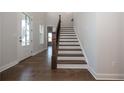 Elegant wooden staircase with dark wood railings and hardwood floors at 517 Pearl St, Cumming, GA 30040