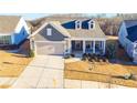 Aerial view of a lovely home featuring a two-car garage and charming dormers, nestled within a landscaped community at 4941 Adler Ct, Hoschton, GA 30548