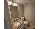 Small bathroom with granite vanity, white toilet, and a mirror at 1334 To Lani Farm Rd, Stone Mountain, GA 30083