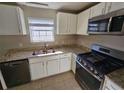 Kitchen with granite countertops, stainless steel appliances, and white cabinets at 1334 To Lani Farm Rd, Stone Mountain, GA 30083