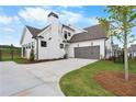 View of the home's exterior, featuring the attached garage and well-maintained lawn at 515 Pearl St, Cumming, GA 30040