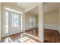 Bright entryway featuring hardwood floors, a white front door with sidelights, and decorative trim at 1656 Hedington Ct, Lawrenceville, GA 30045