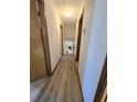 Well-lit hallway with wood-look flooring, leading to rooms, and overhead lighting at 1330 Hillcrest Dr, Sugar Hill, GA 30518