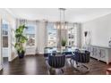 Bright dining room with glass table, dark wood floors, and stylish light fixture at 6146 Eves Way, Norcross, GA 30071