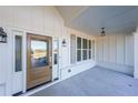 Covered front porch with wood front door and gray shutters at 5470 Crow Dr, Cumming, GA 30041