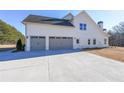 Three-car garage with gray doors and a large concrete driveway at 5470 Crow Dr, Cumming, GA 30041