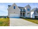 Two-story house with white brick and gray siding, featuring a front porch and attached two-car garage at 5435 Crestline View Rd, Cumming, GA 30028