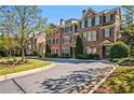 Townhome exterior with a manicured lawn, mature trees, and black shutters at 570 Parkside Village Nw Way # 12, Marietta, GA 30060
