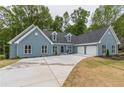 Two-story house with gray siding, three-car garage, and large driveway at 9635 Haverhill Ln, Johns Creek, GA 30022