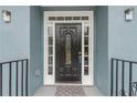 Elegant black front door with sidelights and a welcoming mat at 9635 Haverhill Ln, Johns Creek, GA 30022