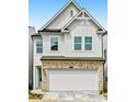 Charming two-story home featuring a white exterior, brick accents, and an attached two-car garage at 711 Smokey Quartz Way, Kennesaw, GA 30144