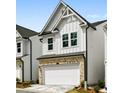 Well-maintained home showcasing a white exterior with a brick-base garage and a neatly landscaped yard at 711 Smokey Quartz Way, Kennesaw, GA 30144