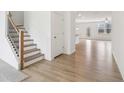 Bright entryway with hardwood floors, staircase, and an open layout to the living area creating a spacious and inviting atmosphere at 7289 Eton Ln, Locust Grove, GA 30248