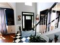 Spacious entryway with a black front door, checkerboard floor, and staircase at 3854 Heritage Crest Pkwy, Buford, GA 30519