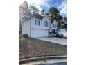 Split-level home featuring a two-car garage, gray trim, and well-maintained lawn at 5619 Mayfair Crossing Dr, Lithonia, GA 30038