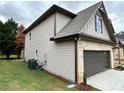 Side view of house showcasing gray siding and a dark gray garage door at 1534 Stargrass Dr, Grayson, GA 30017