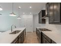 Modern kitchen with dark cabinetry, quartz countertops, and stainless steel appliances at 548 Sawnee Village Blvd # D72, Cumming, GA 30040