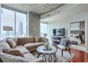 Open concept living room with city views, sectional sofa and hardwood floors at 855 Peachtree Ne St # 2307, Atlanta, GA 30308