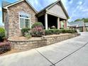 Charming stone and siding home with a covered porch, decorative landscaping, and a paved driveway at 4140 Lanier Ridge Walk # 104, Cumming, GA 30041
