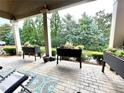 Covered patio with lounge chairs, brick floor and mature landscaping at 4140 Lanier Ridge Walk # 104, Cumming, GA 30041