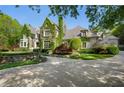 Elegant stone home with lush ivy accents, complemented by manicured landscaping at 3685 Paces Ferry Nw Rd, Atlanta, GA 30327