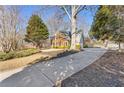 Long driveway leading to a two-story house nestled among trees at 5480 Landseer Way, Cumming, GA 30040