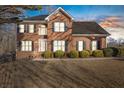 Brick two-story house with a landscaped lawn, nighttime view at 5480 Landseer Way, Cumming, GA 30040