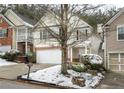 Two-story townhome with a white garage door and snow-covered landscaping at 646 Lakes Cir, Lithonia, GA 30058