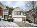 Two-story townhome with a white garage door and snow-covered landscaping at 646 Lakes Cir, Lithonia, GA 30058