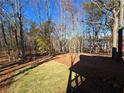 View of the backyard, showing a sloped lawn and trees at 135 Cedarwood Ln, Roswell, GA 30075