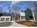 Contemporary home featuring a stylish green exterior with a connecting garage and modern design at 135 Cedarwood Ln, Roswell, GA 30075