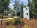 Modern home with professionally landscaped yard and a well-manicured lawn at 135 Cedarwood Ln, Roswell, GA 30075