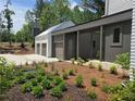 Beautifully landscaped yard featuring an attached, multi-car garage, modern design, and fresh plantings at 135 Cedarwood Ln, Roswell, GA 30075