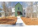 Modern home showcasing distinctive green siding, a walkway, and unique architectural details at 135 Cedarwood Ln, Roswell, GA 30075