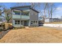 Modern two-story house with gray and teal siding, a porch, and a yard at 3463 Victoria St, Atlanta, GA 30337