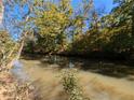 Scenic view of a tranquil pond surrounded by lush trees under a bright blue sky, reflecting nature's beauty at 1275 Poole Bridge Rd, Hiram, GA 30141