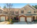 Inviting townhouse showcasing well-maintained landscaping, brick accents, and attached single-car garages at 168 Ellis Dr, Conyers, GA 30012