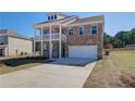 Two-story brick home with balcony, attached garage, and landscaped yard at 205 Chiswick Loop, Stockbridge, GA 30281