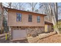 Two-story house with wood siding, stone base, and attached garage at 1482 Kings Ridge Dr, Norcross, GA 30093