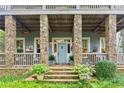 Home features a light blue front door and stone columns at 9032 Selborne Ln, Chattahoochee Hills, GA 30268