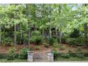 Two-story house nestled among trees, stone steps leading to entrance at 9032 Selborne Ln, Chattahoochee Hills, GA 30268