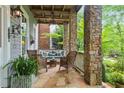 Charming covered porch with flagstone flooring, exposed stone supports and outdoor seating, perfect for relaxation at 9032 Selborne Ln, Chattahoochee Hills, GA 30268