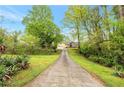 Long driveway leading to a charming yellow house nestled among lush greenery at 4050 Old Fairburn Rd, Atlanta, GA 30349