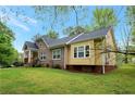 Side view of a charming yellow house with a large backyard at 4050 Old Fairburn Rd, Atlanta, GA 30349