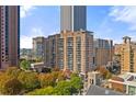 An exterior view of a high-rise apartment building with multiple balconies and surrounding greenery at 620 Peachtree Ne St # 1412, Atlanta, GA 30308